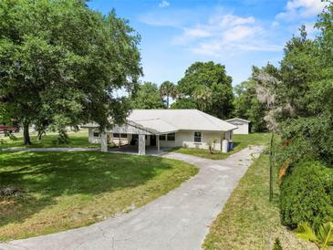 Charming home with a long driveway and lush greenery all around the property at 103 S Flagler Ave, Edgewater, FL 32132