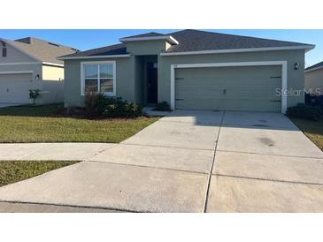 Well-maintained single-story home with a two-car garage and a neatly manicured front lawn at 357 Summershore Dr, Auburndale, FL 33823