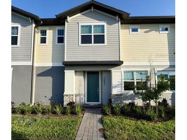 Attractive two-story townhome with neutral-colored siding, tidy landscaping, and a welcoming front entrance at 3842 Knotty Pine St, St Cloud, FL 34772