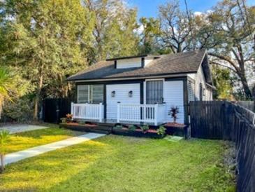 Charming home with a manicured lawn and a quaint white picket fence surrounding the front porch at 608 Grand St, Orlando, FL 32805