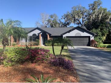 Charming single story home with a well manicured lawn and colorful landscaping including palm trees at 3822 Kinsley Pl, Winter Park, FL 32792