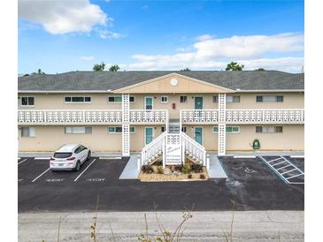 Condominium building featuring well maintained landscaping, multiple guest parking spots, and stairwell access at 335 N Causeway # E3, New Smyrna Beach, FL 32169