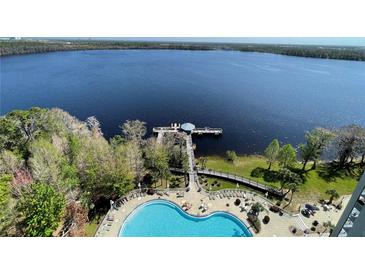 Breathtaking aerial view of a lakefront community featuring a pool and pier at 13415 Blue Heron Beach Dr # 1407, Orlando, FL 32821