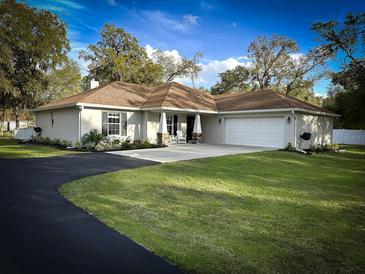 Charming single-story home with well-manicured lawn, circular driveway, and attached two-car garage at 9233 Tom Moore Rd, Lakeland, FL 33810