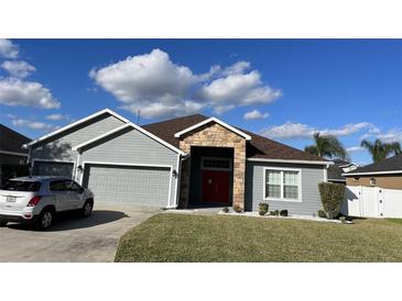 Charming single-story home with gray siding, stone accents, and a well-manicured lawn at 2822 Seymore St, Lakeland, FL 33813