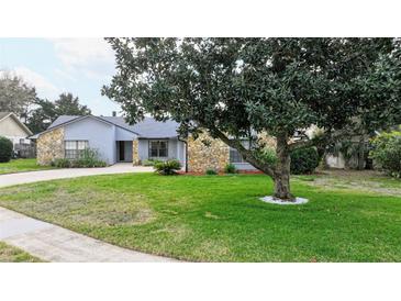 Charming single-story home featuring stone accents, a well-manicured lawn, and mature landscaping at 1776 E Cheryl Dr, Winter Park, FL 32792