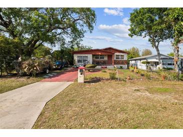 Charming single-story home featuring a well-maintained front yard and a red-colored driveway at 1222 Avenue M, Haines City, FL 33844