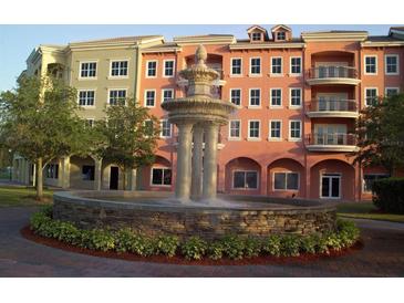 Beautiful condo building featuring a central fountain, lush landscaping, and vibrant colors at 424 Luna Bella Ln # 330, New Smyrna Beach, FL 32168