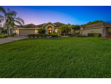 Sprawling lawn and manicured hedges highlight this single-story home with attached garage and barrel tile roof at 4435 Fairway Oaks Dr, Mulberry, FL 33860