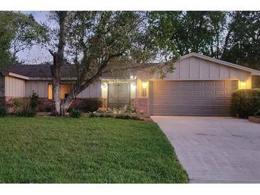 Charming single-story home with a well-maintained lawn, mature trees, and welcoming curb appeal at dusk at 568 Gainsboro St, Deltona, FL 32725