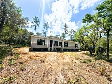 New home exterior, showing grey siding, black shutters, and an unfinished front yard at 9124 Sw 158Th Ln, Dunnellon, FL 34432