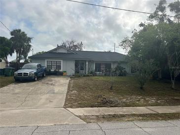 Modest single story home with a lawn and a blue truck in the driveway at 1400 Hayward Ave, Deltona, FL 32738