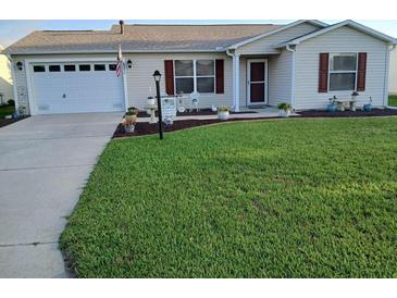 Charming single-story home boasts a well-manicured lawn and attached two-car garage at 3405 Forsythe Ter, The Villages, FL 32162