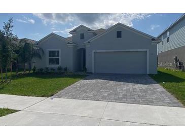 Charming single-story home featuring a gray exterior, well-maintained lawn, and a two-car garage at 4910 Lyric Dr, Mascotte, FL 34753