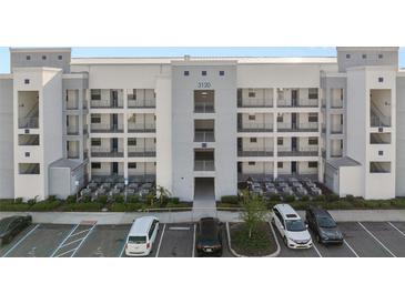 Modern condominium building featuring a sleek design with multiple floors and ample parking at 3120 Paradox Cir # 307, Kissimmee, FL 34746