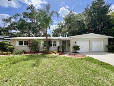 Charming single-story home with lush landscaping and a well-manicured lawn at 3610 Pershing Ave, Orlando, FL 32812