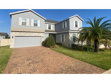 Charming two-story home featuring a brick driveway, two-car garage, and well-maintained landscaping at 1142 Blarney St, Minneola, FL 34715