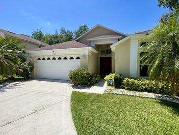 Charming single-story home with well-manicured lawn and a two-car garage, nestled in a tropical landscape at 1003 Clearpointe Way, Lakeland, FL 33813