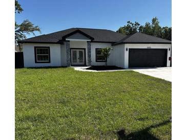 Charming single story home featuring a manicured lawn, gray and white exterior paint, and a black asphalt shingle roof at 8456 Se 164Th Pl, Summerfield, FL 34491