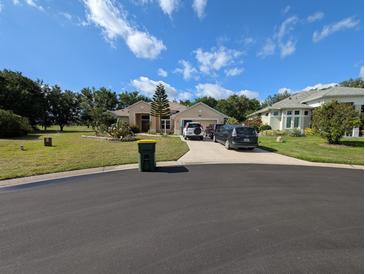 Charming home with well-manicured lawn, complemented by a blue sky at 5352 Treasure View Way, Leesburg, FL 34748