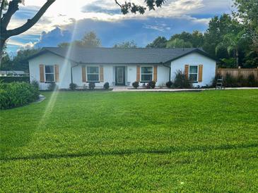 Charming home featuring a sprawling green lawn, white exterior, and classic shutters at 1114 Dove Ln, Winter Springs, FL 32708