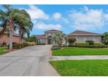 Beautiful single-story home featuring a well-manicured lawn, lush landscaping, and a long driveway leading to the front entrance at 508 Bacio St, New Smyrna Beach, FL 32168