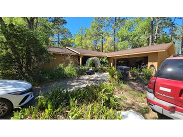 Exterior shot of the home with mature landscaping and an arched entrance at 20045 Sw 88Th Place Rd, Dunnellon, FL 34431