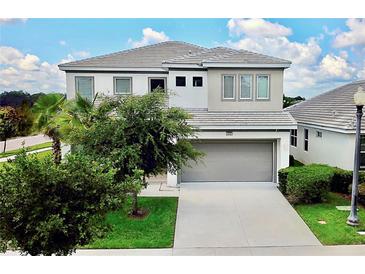 Beautiful two-story home with a gray tiled roof, concrete driveway, and well-manicured landscaping at 4500 Monado Dr, Kissimmee, FL 34746
