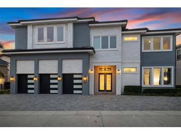 Stunning two-story home with modern design, three-car garage, and beautifully landscaped front yard at 1514 Corolla Ct, Reunion, FL 34747