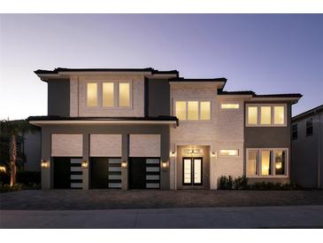 Beautiful two-story home featuring a three-car garage, modern design, and inviting front entrance with sidelights at 1514 Corolla Ct, Reunion, FL 34747
