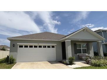 Charming single-story home with a two-car garage, a covered front porch and simple landscaping at 5216 Greenheart Ave, Mount Dora, FL 32757