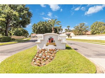 Elegant Vizcaya community entrance sign with lush landscaping and a clear blue sky backdrop at 8749 The Esplanade # 6, Orlando, FL 32836