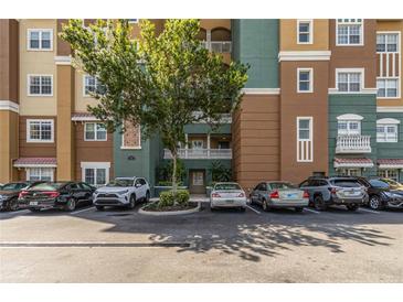 Well-maintained condo exterior with colorful facade, balconies and parking lot for residents at 8749 The Esplanade # 6, Orlando, FL 32836