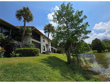 Scenic exterior view of lakeside home with lush landscaping and mature palm trees at 200 Maitland Ave # 114, Altamonte Springs, FL 32701
