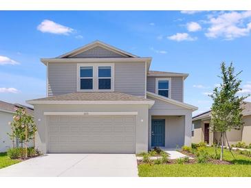 Charming two-story home showcasing a neutral color palette, well-manicured lawn, and an attached two-car garage at 5133 Forget Me Not Ave, Lake Hamilton, FL 33851