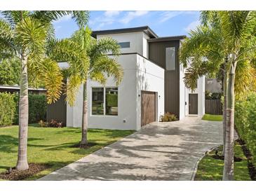 Modern two-story home with meticulously landscaped front yard and paver driveway, surrounded by mature palm trees at 1521 Chestnut Ave, Winter Park, FL 32789