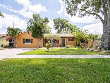 Charming single-story home featuring a lush green lawn, mature trees, and welcoming front entrance at 4209 Forrestal Ave, Orlando, FL 32806