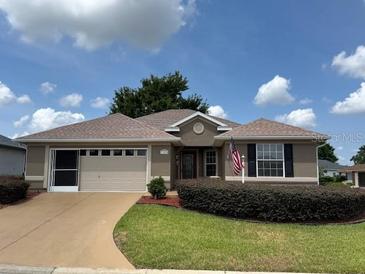 Charming single-story home with a well-manicured lawn and a two-car garage at 17430 Se 110Th Ter, Summerfield, FL 34491