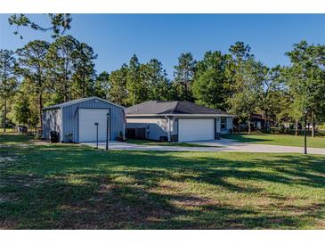 Charming home featuring an extra building, beautiful lawn, and long driveway at 9085 Sw 202Nd Avenue Rd, Dunnellon, FL 34431