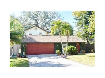 Charming home featuring an attached two-car garage, well-maintained landscaping, and mature palm trees at 1823 Sunset Dr, Winter Park, FL 32789