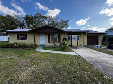 Charming single-story home with a metal roof, mature landscaping, and a welcoming front yard at 15 Monroe Ave, Debary, FL 32713