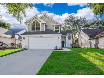 Charming two-story home showcasing a well-manicured lawn and an attached two-car garage at 1839 Cranberry Isles Way, Apopka, FL 32712