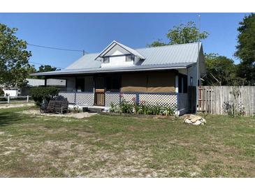 Charming single-story home with a metal roof, lattice accents, and a cozy front porch area at 705 Grape Ave, St Cloud, FL 34769