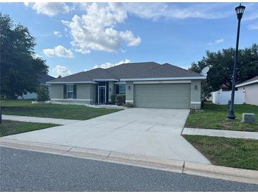Charming single-story home featuring a well-maintained lawn, two-car garage, and inviting front entrance at 31517 Broadwater Ave, Leesburg, FL 34748