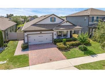 Charming single-Gathering home featuring a 2-car garage, landscaped yard, and covered porch at 1896 Napoli Dr, St Cloud, FL 34771