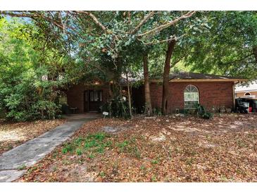 Quaint brick home with mature trees providing shade and curb appeal at 418 W Holly Dr, Orange City, FL 32763