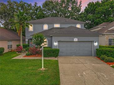 Charming gray two-story home featuring a well-manicured lawn and a spacious two-car garage at 9525 Southern Garden Cir, Altamonte Springs, FL 32714