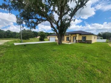 Charming single-story home with a well-manicured lawn and a spacious driveway at 13074 Sw 104Th Ln, Dunnellon, FL 34432