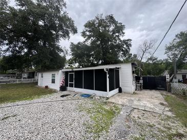 Charming home featuring a screened porch and a spacious gravel driveway at 721 Crestview Dr, Casselberry, FL 32707