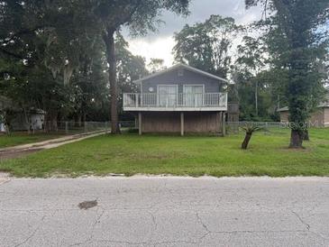 Charming two-story home featuring a well-maintained lawn and mature trees at 5641 Nw 55Th Ave, Ocala, FL 34482